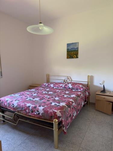 a bedroom with a bed with a floral bedspread at Agriturismo Bufaleria in Scanzano