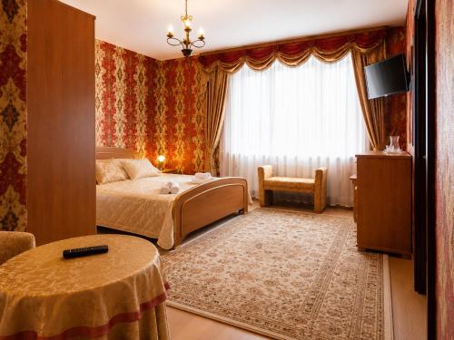 a bedroom with a bed and a table and a window at Pensjonat Angela in Łeba