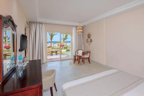 a hotel room with a bed and a table and chairs at Royal Brayka Beach Resort in Marsa Alam City