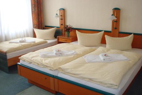 two beds in a room with towels on them at Zur Alten Brauerei in Jessen