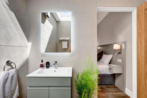 a bathroom with a sink and a bed in a room at Millmaster Apartment in Drumahayre