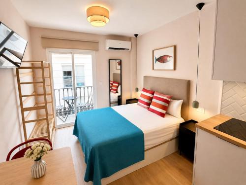 a small bedroom with a bed and a balcony at 10ToSea Premium Hostal in Fuengirola