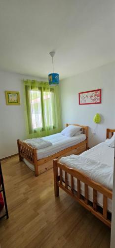 two beds in a room with wooden floors at Gîte Xuritenborda 7 personnes avec vue exceptionnelle sur les montagnes basque, Lits 180 King Size in Ossès