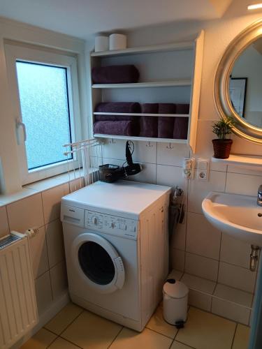 a washing machine in a bathroom with a sink at Heringsmoewe in Tossens
