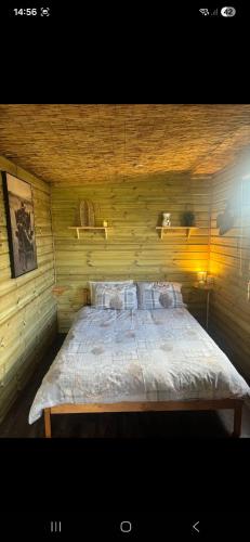 a bedroom with a large bed in a wooden wall at The Mid Devon Retreat in Crediton