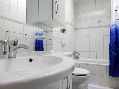 a white bathroom with a sink and a toilet at Guest House Frane in Pag