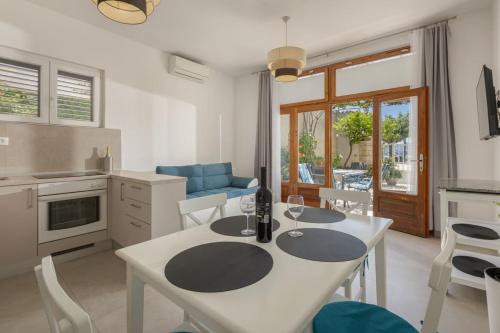 a kitchen with a table and chairs in a room at Apartment Amfora in Podgora