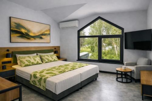 a bedroom with a bed and a tv and a window at Raya Boutique in Sunny Beach