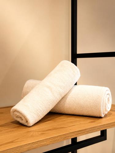 a stack of towels sitting on a wooden shelf at Blester Hotel Golem Durres in Golem