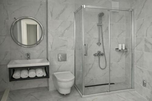 a bathroom with a shower and a toilet and a sink at Raya Boutique in Sunny Beach