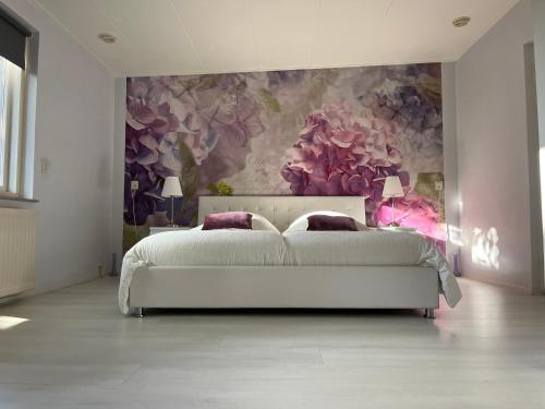 ein Schlafzimmer mit einem weißen Bett und einer Blumenwand in der Unterkunft Brissago in Nes