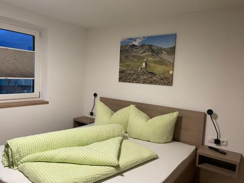 a bedroom with a bed with yellow pillows at Berghoamat Nauders in Nauders