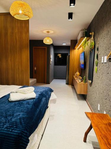a bedroom with a bed with blue sheets and a television at Studio Patacho Rota dos Milagres in Pôrto de Pedras