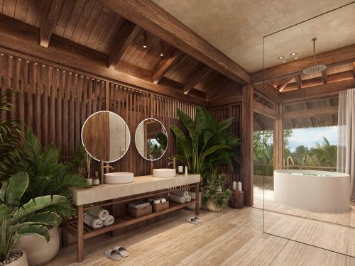 a bathroom with two sinks and a tub and plants at The Kontiki in Willemstad
