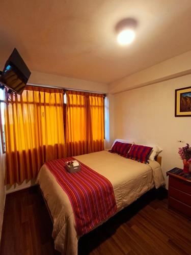a bedroom with a bed with a red blanket on it at VittoriaHouse in Ollantaytambo