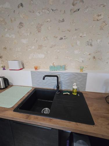 a kitchen counter with a black sink in a kitchen at Studio moderne en hyper-centre de Vendôme in Vendôme
