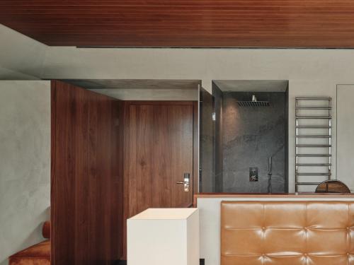 ein Wohnzimmer mit einer Holztür und einer braunen Tür in der Unterkunft Hotel Aurora in Meran