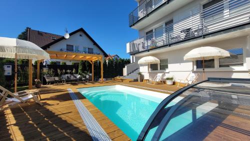 a house with a swimming pool next to a building at GoldenApart Apartamenty 2-sypialniowe - Grzany Basen - Kameralny Klimat in Krynica Morska