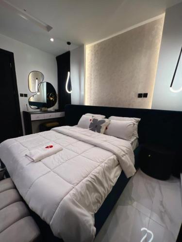 a bedroom with a large bed with white sheets and pillows at Fa Apartment in Lekki