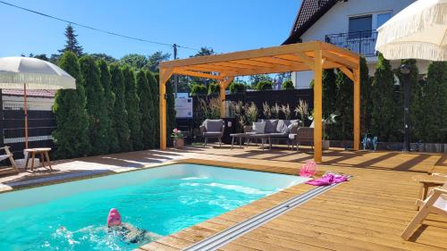 a swimming pool in a backyard with a pergola at GoldenApart Apartamenty 2-sypialniowe - Grzany Basen - Kameralny Klimat in Krynica Morska