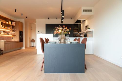 a kitchen with a table with a vase of flowers on it at The Strand Agency - June in Cadzand-Bad