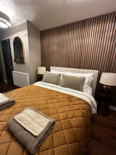 a bedroom with a large bed with a blanket on it at Tree Top & Bluebell Cottages in Grange Road Station