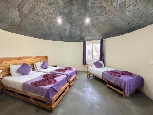 two beds in a room with a painting on the ceiling at EcoFunco in Portela