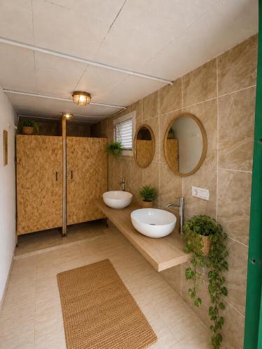 a bathroom with two sinks and two mirrors at Pink lemon Galmping in Elche