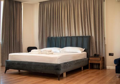 a bed with a blue headboard in a room at HOTEL LIBERTAS in Vlorë