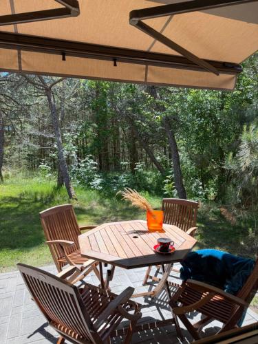 a wooden table and chairs on a patio at Poilsis Urbo Nidoje in Nida