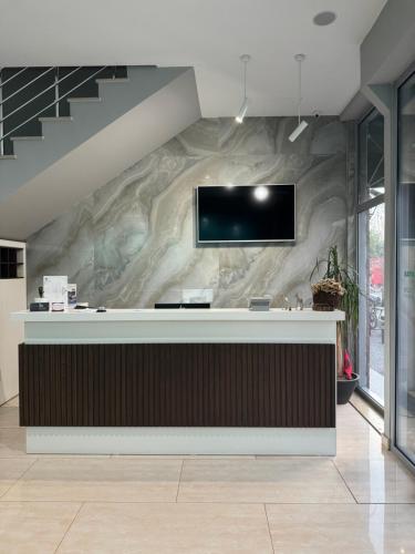 a lobby with a tv on a marble wall at HOTEL LIBERTAS in Vlorë