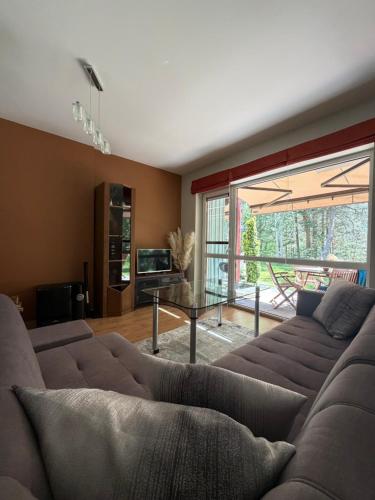 a living room with a couch and a large window at Poilsis Urbo Nidoje in Nida
