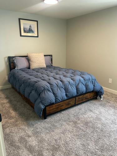 a bedroom with a large bed with a blue blanket at Thirty-Six Street Retreat in Missoula