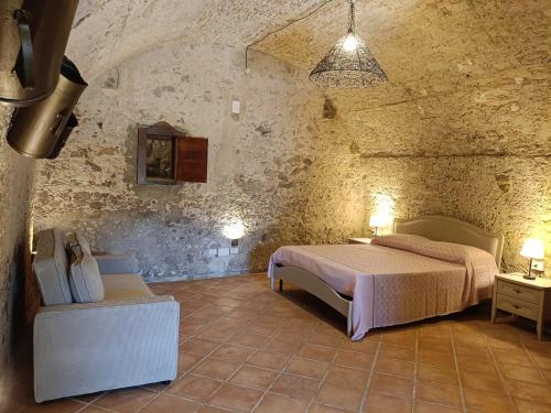 a bedroom with a bed in a stone room at Residenza La Vigna in Parghelia