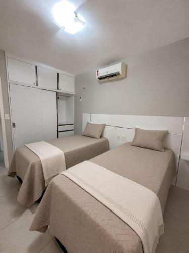two beds in a room with a heater on the wall at WaiWai Residence Cumbuco in Caucaia