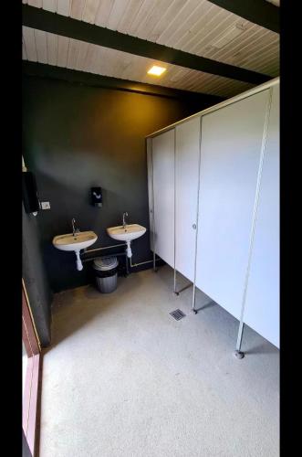 a bathroom with two sinks and a wall with stalls at Šķilas in Pērkone