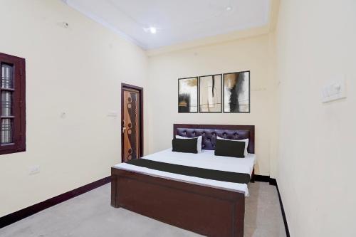 a bedroom with a bed in a white room at Hotel O Relax Inn in Lucknow