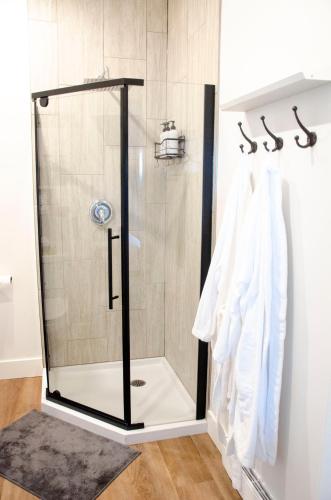 a shower with a glass door in a bathroom at Blue Moon Bungalow in Tillsonburg