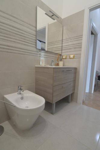 a white bathroom with a sink and a mirror at Loredana's House in Pachino