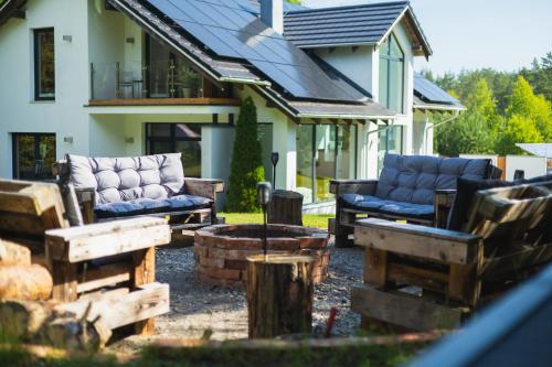 a patio with couches and a fire pit in front of a house at Willa Vivaldi - Family & Friends - Sauna, Balia in Grzybowo