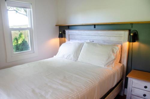 a bedroom with a white bed and a window at Blue Moon Bungalow in Tillsonburg