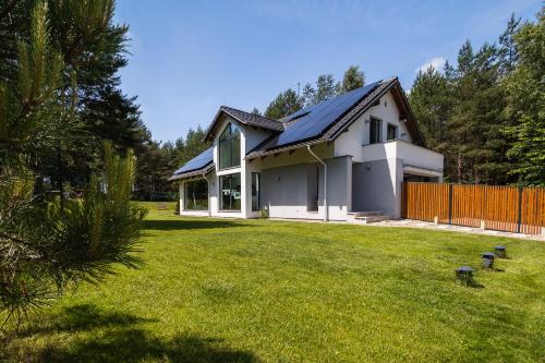 a house with a solar roof on a yard at Willa Vivaldi - Family & Friends - Sauna, Balia in Grzybowo