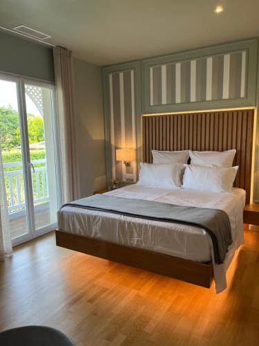 a bedroom with a large bed and a large window at ViLLA HELENA - anciennement LE CLOS D'IGNAC in Lège-Cap-Ferret