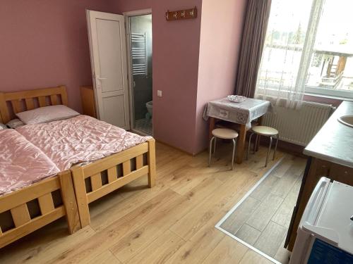 a bedroom with a bed and a table with chairs at Bakuriani Mtis 6 in Bakuriani