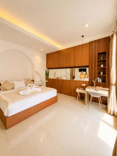 a bedroom with a bed and a desk at Asania Villa in Uluwatu