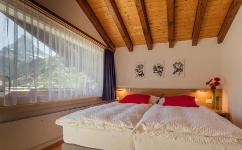 ツェルマットにあるChalet Sonneggのベッドルーム1室(ベッド1台、大きな窓付)