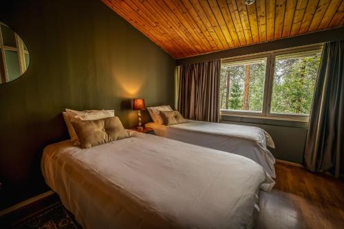 a bedroom with two beds and a window at Sveitsin Maja in Hyvinkää