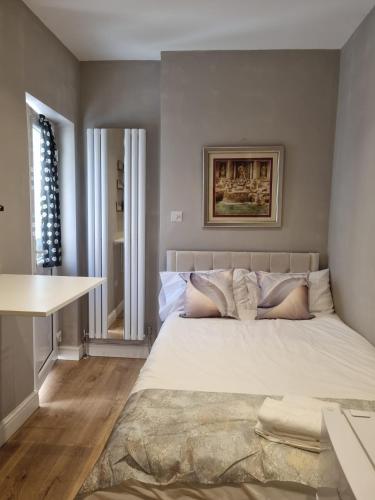 a bedroom with a large bed and a table at Luxury Flats - Hendon in Colindale