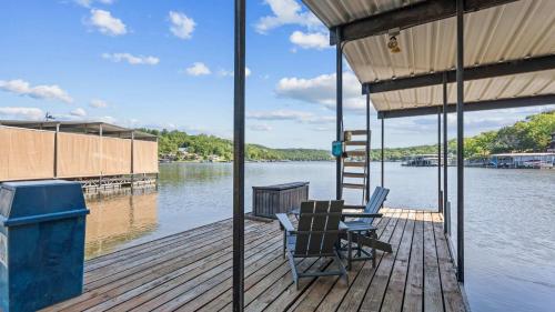 a dock with two chairs and a ladder on the water at Honey Hole 3 Well Dock in Camdenton