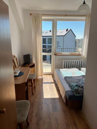 a bedroom with a bed and a large window at Willa Lazur in Władysławowo